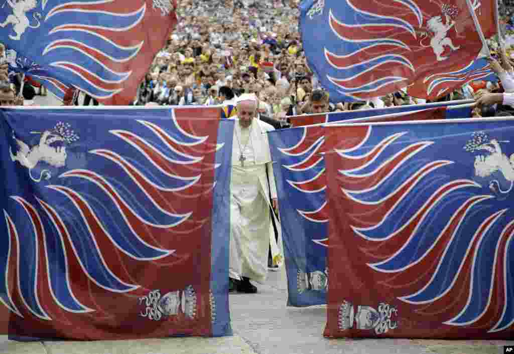 Paus Fransiskus&nbsp;tampak dikelilingi oleh bendera tradisional yang dibawa oleh&nbsp;delegasi dari Carovigno, Italia selatan, saat tiba di Santo Petrus, Vatikan. 