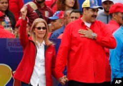 FILE - Venezuela's President Nicolas Maduro and first lady Cilia Flores acknowledge supporters at the end of a rally in Caracas, Venezuela, Feb. 2, 2019.