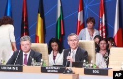 FILE - NATO Secretary General Jens Stoltenberg, right, and Ukraine's President Petro Poroshenko attend a working session of the NATO-Ukraine Commission at the NATO summit in Warsaw, Poland, July 9, 2016.