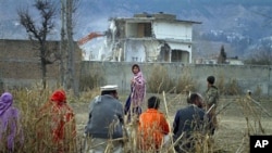 A Pakistan family watches the destruction of Osama bin Laden's compound in Abbottabad, Pakistan, February 26, 2012.
