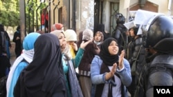 Para mahasiswi berbicara pada polisi dalam sebuah protes di Al-Azhar University di Kairo. (Foto: dok/VOA-Hamada Elrasan)