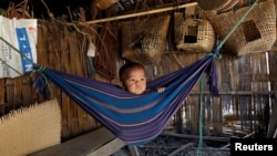 Tina Chakma, a six-month-old baby girl plays in an improvised hammock inside her parents' house on the outskirts of Agartala, India, March 20, 2018.