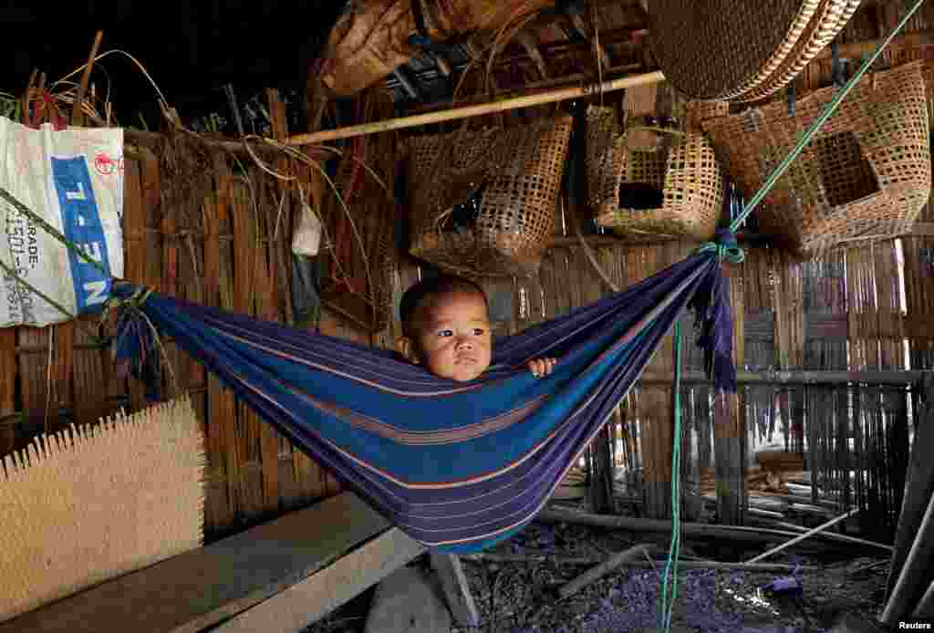 Tina Chakma, a six-month-old baby girl, plays in an improvised hammock inside her parents&#39; house on the outskirts of Agartala, India.
