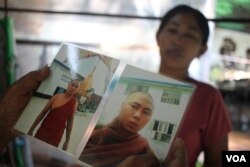 Daw Aye holds a photo of her son, who died after being taken into police custody last year (J. Carroll/VOA)