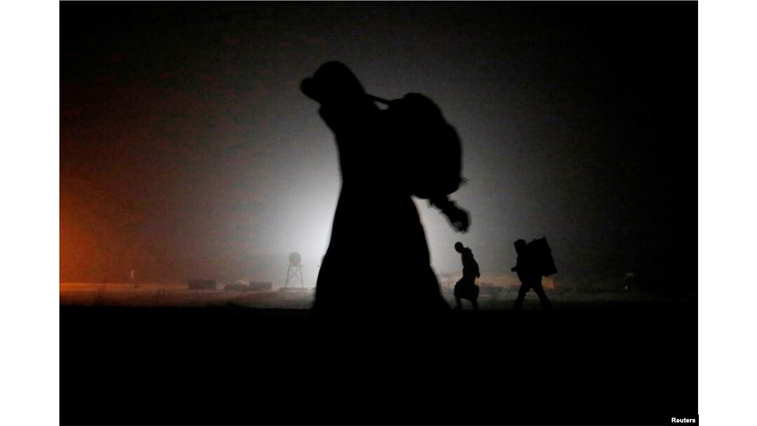 FILE - A group of migrants who said they were from Djibouti and Somalia walk along railway tracks after crossing the Canada-U.S. border in Emerson, Manitoba, Canada, March 27, 2017.