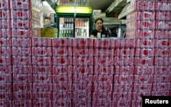 FILE - Crates of Coca-Cola are seen stacked outside a counter of a coffee shop in Singapore, March 14, 2013.