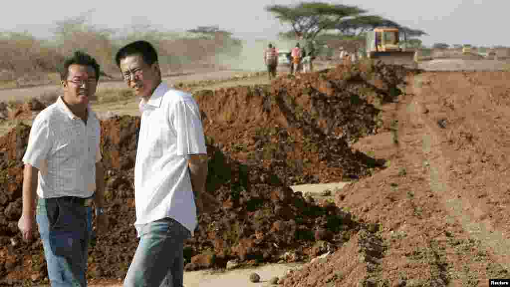 Wu Yi Bao (d), gestionnaire de projet de construction de route de la société Chine Wuyi, discute avec un collègue sur le site de travaux près de la ville d&#39;Isiolo, à environ 320 km&nbsp; au nord de Nairobi, Kenya, 7 juillet 2008.