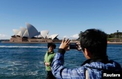 Một du khách Trung Quốc chụp ảnh trước Nhà hát Sydney.