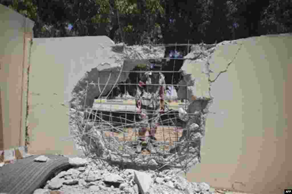 A rebel fighter looks at damages in a house at the town of Brega, Libya, Monday, Aug. 15, 2011. Most of the town has been liberated from Moammar Gadhafi's forces, with fights going on only at the oil terminal, according the rebel military spokesman, Ahmed