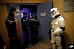In this Feb. 10, 2019, photo, a man dressed up as Stormtrooper and French gendarmes watch a national lightsaber tournament in Beaumont-sur-Oise, north of Paris.