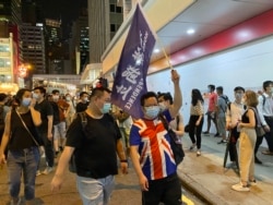 有游行人士身穿印上英国国旗的T恤，高举香港独立旗帜 (美国之音/汤惠芸）