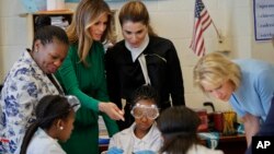 From left, school Principle Dana Bogle, first lady Melania Trump, Queen Rania of Jordan and Education Secretary Betsy DeVos talk with students during a science class at the Excel Academy Public Charter school in Washington, April 5, 2017. 