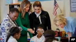 FILE - From left, school Principal Dana Bogle, first lady Melania Trump, Queen Rania of Jordan and Education Secretary Betsy DeVos talk with students during a science class at the Excel Academy Public Charter School in Washington, April 5, 2017. 