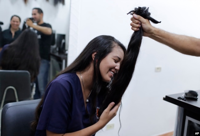 Valery Díaz holds the hair she had cut off to earn $100 in Caracas, Venezuela, April 5, 2019.