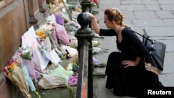 A woman lays flowers for the victims of the Manchester Arena attack, in central Manchester, Britain, May 23, 2017. 