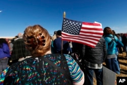 A woman holds an American flag during a rally in support of Jeanette Vizguerra, a Mexican woman seeking to avoid deportation from the United States, outside the Immigration and Customs Enforcement office in Centennial, Colorado, Feb. 15, 2017.