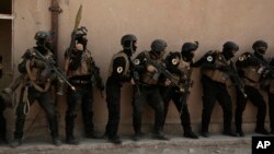 FILE - Soldiers from the 1st Battalion of the Iraqi Special Operations Forces are stacked against a building during a training exercise to prepare for the operation to retake Mosul from Islamic State militants, in Baghdad, Iraq, Aug. 13, 2016. 
