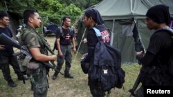 Members of special police force chat after returning to a police camp near Wang Kelian in northern Malaysia, close to the border with Thailand May 25, 2015. Malaysian authorities have found 139 graves, and signs of torture, in more than two dozen squalid 