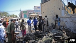 People look at the wreckage of a car bomb outside the Education Ministry in Mogadishu, April 14, 2015. 