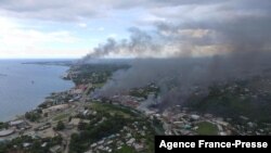 从所罗门群岛首都霍尼亚拉被焚烧的建筑冒出的浓烟。(2021年11月25日)