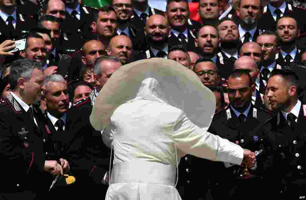 A gust of wind blows Pope Francis' mantel as he meets the Carabinieri during the general audience in Saint Peter's Square at the Vatican.