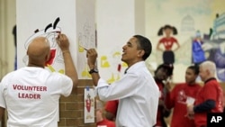 President Barack Obama helps to paint cartoon characters in a lunchroom as he observes the Martin Luther King Jr. Day holiday, 17 Jan 2011