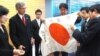 Japanese Prime Minister Shinzo Abe (C) examines the "good luck flag" that Dallas Britt took in battle and then returned 70 years later. Keiko and Rex Ziak stand at left. (Courtesy - Obon 2015)
