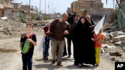 People flee their homes on April 12, 2016, during clashes between Iraqi security forces and Islamic State group in Hit, 85 miles (140 kilometers) west of Baghdad, Iraq. (AP Photo)