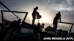 Des Congolais déplacés emballent des bateaux pour s'échapper sur le lac Albert vers l'Ouganda, le 5 mars 2018 à Tchomia.