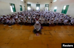 FILE - Students pray during the first day of the holy month of Ramadan at Al-Mukmin Islamic boarding school in Solo, in Indonesia's Central Java province, August 1, 2011.