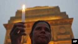 A mourner attends a candlelight prayer ceremony for nun Valsha John at the India Gate in New Delhi, November 22, 2011. John, 52, was beaten and hacked with an axe by unknown assailants in India's eastern Jharkhand state where she had led a campaign for fi