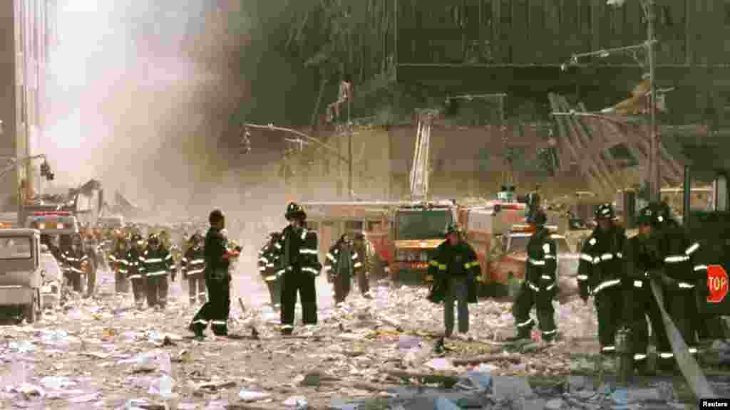 Des pompiers de New York et d&rsquo;autres membres du personnel d&#39;urgence s&rsquo;activent&nbsp; dans la zone de l&#39;effondrement du World Trade Center à proximité de rues Vessey et Greenwich, 11 septembre 2001.