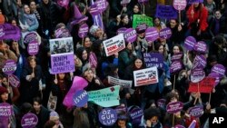 Protesters, mostly women, display various placards calling to end violence towards women, and chant slogans during a rally in central Istanbul, Sunday, Nov. 25, 2018.