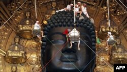 Biksu Buddha dan relawan membersihkan patung Buddha besar setinggi 15 meter selama upacara tahunan Ominugui di Kuil Todaiji di ibu kota kuno Jepang, Nara, Jepang barat. (Foto: AFP)