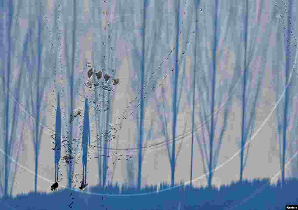 People cast their shadows on a snow-covered field while taking a walk at a park in Chuncheon, South Korea. (Credit: Yonhap)