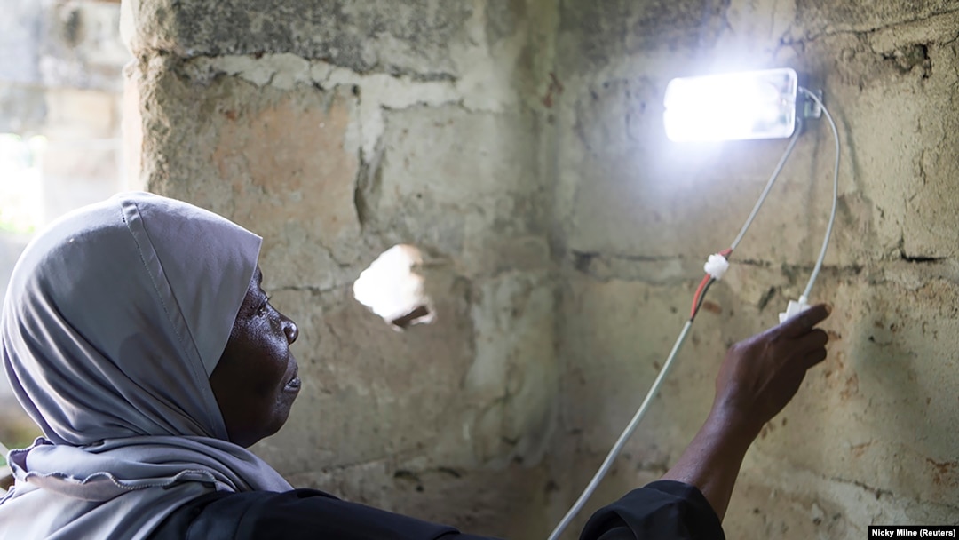  Seorang perempuan sedang memasang lampu surya sebagai ilustrasi. (Foto: Reuters/Nicky Milne)