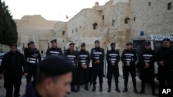 Palestinian police line up next to Church of the Nativity, traditionally believed to be the birthplace of Jesus, on Christmas Eve, in the West Bank city of Bethlehem, Dec. 24, 2024.