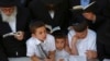 Visitors pray at the gravesite of the 'Lubavitcher Rebbe,' Rabbi Menachem Mendel Schneerson, at the Old Montefiore Cemetery in the Queens borough of New York June 30, 2014.