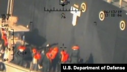 Foto dari Pentagon yang diambil dari helikopter AL AS menunjukkan anggota Garda Revolusioner Iran mengambil ranjau limpet dari kapal M/T Kokuka Courageous.