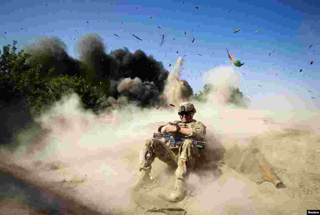 May 31: Jake Beaudoin, a U.S. Army Private, takes cover during a controlled detonation in Kandahar province, southern Afghanistan.