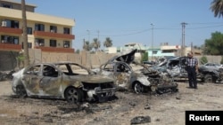A man looks at damaged vehicles at the site of a car bomb attack in Baghdad's Kadhimiya district, September 30, 2013.