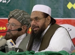 FILE - Hafiz Mohammad Saeed, right, chief of Jamaat-ud-Dawwa and founder of Lashkar-e-Taiba, addresses a news conference with anti-American cleric Sami ul Haq in Rawalpindi, Pakistan, April 4, 2012.