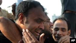 کراچی میں پانچ فروری کو ایک بس پر موٹر سائیکل بم حملے کے بعد ایک شخص ماتم کر رہا ہے
