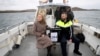 Presiding officer Caroline Sharkey and Garda Ronan Steede look after a ballot box that is taken by boat to the Island of Gola as voters go to polls for the 2024 election in Ireland on Nov. 29, 2024.