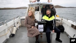 Presiding officer Caroline Sharkey and Garda Ronan Steede look after a ballot box that is taken by boat to the Island of Gola as voters go to polls for the 2024 election in Ireland on Nov. 29, 2024.