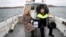 Presiding officer Caroline Sharkey and Garda Ronan Steede look after a ballot box that is taken by boat to the Island of Gola as voters go to polls for the 2024 election in Ireland on Nov. 29, 2024.