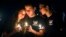 Attendees comfort each other at a candlelight vigil for the victims of the shooting at Marjory Stoneman Douglas High School, Feb. 15, 2018, in Parkland, Fla. 