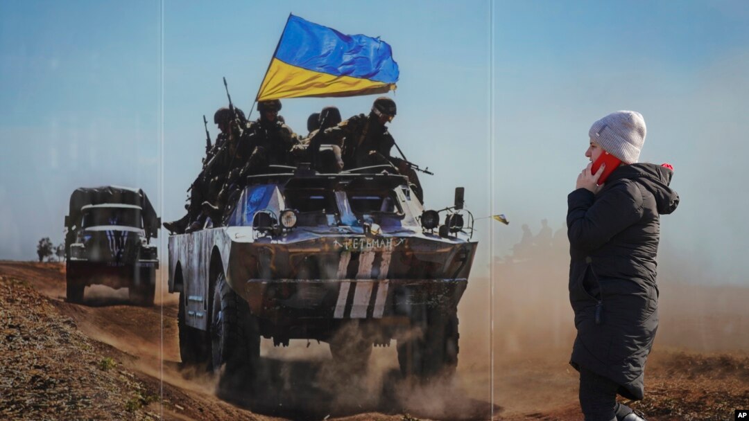 Lugansk, 23-fevral, 2022: Severodonetsk shahrida ukrain harbiylarining banneri oldidan o'tib ketayotgan ayol 