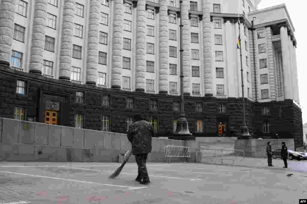 Дворник с метлой возле Дома правительства после митинга ликвидаторов Чернобыльской катастрофы