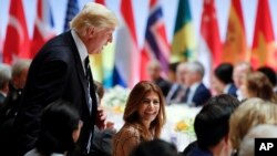 El presidente Donald Trump conversa brevemente con Juliana Awada, la esposa del presidente argentino Mauricio Macri, en la cena en la que también conversó con Putin en Hamburgo.